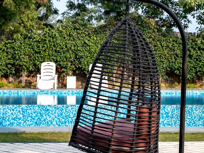 Wicker hanging chair outside of the Safe House Wellness Retreat India